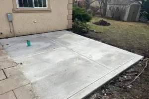Excavated backyard area prepared for new concrete patio and sidewalk installation in Alsip, IL.