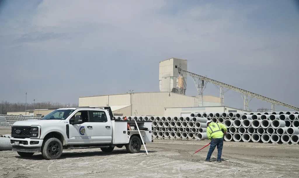 C Corona Construction crew performing underground utility installation and site development work at a precast concrete facility.