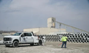 C Corona Construction crew performing underground utility installation and site development work at a precast concrete facility.